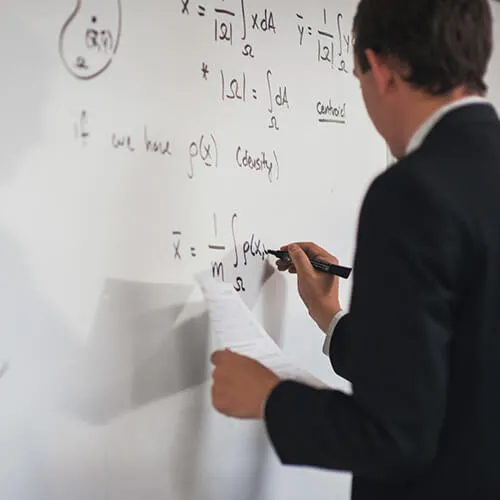 faculty member writing on white board